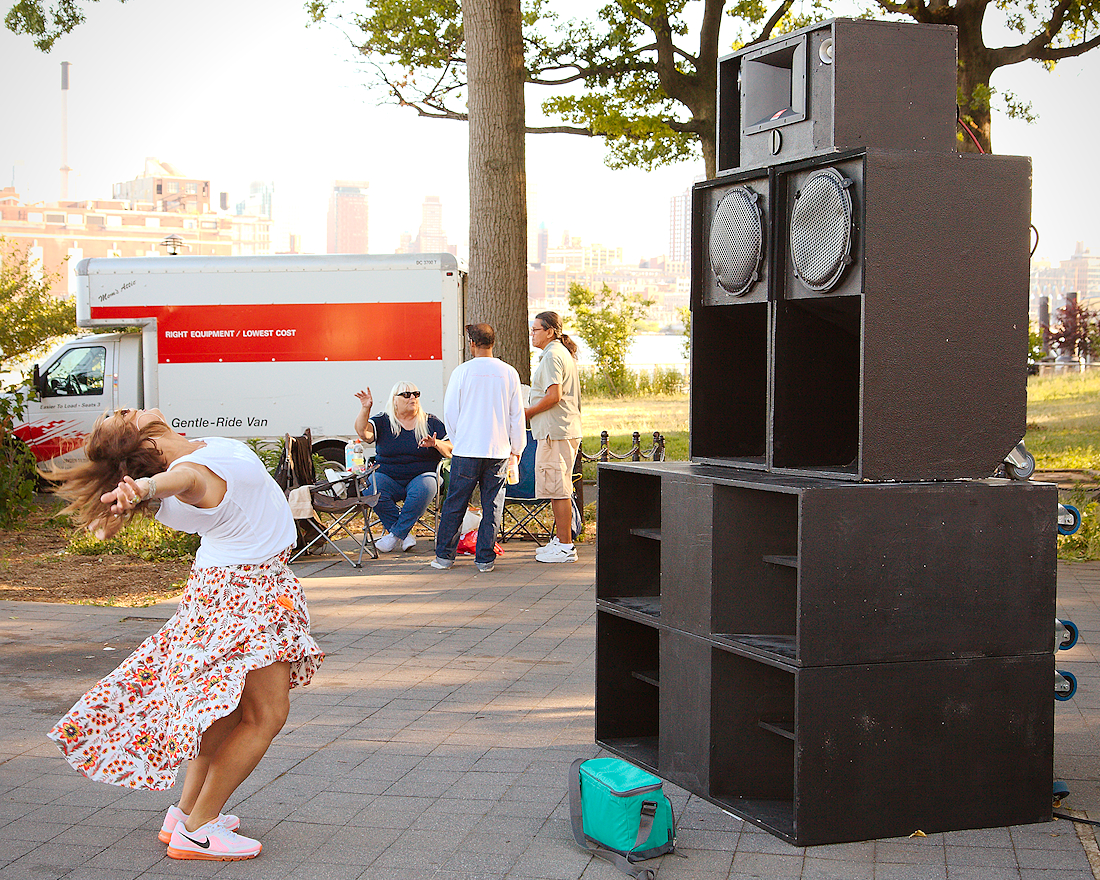 a person dances in front of a stack of speakers